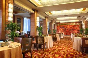 un comedor con mesas y sillas y un mural en Min Zu Hotel, en Beijing