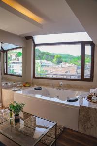 ein großes Bad mit einer großen Badewanne und einem großen Fenster in der Unterkunft Black Bird Thermal Hotel & SPA in Gokcedere