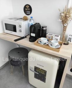 einen Tisch mit einer Mikrowelle und einer Kaffeemaschine in der Unterkunft La planque du raton laveur in Lierneux