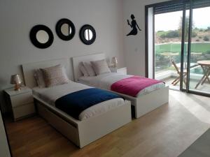 due letti in una stanza bianca con una finestra di Splendide villa Anarouz avec piscine ad Agadir