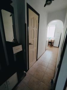 a hallway with a white door and a table at Однокомнатная квартира у моря in Gagra