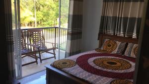 a bedroom with a bed with a view of a balcony at Dream Forest Rest in Ahangama