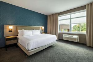 a bedroom with a large bed and a large window at Comfort Inn & Suites in Kingston