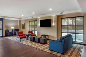 a waiting room with a blue couch and chairs at Comfort Inn & Suites in Charlottesville