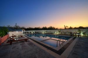 una piscina con panchina e tavolo di Ranthambore Nature Camp Resort a Sawai Madhopur