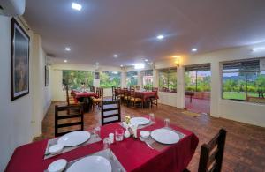 a dining room with a red table and chairs at Ranthambore Nature Camp Resort in Sawāi Mādhopur