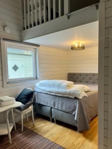 1 dormitorio con cama, mesa y ventana en Hills Cottage en Gränna
