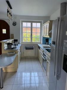 a kitchen with white appliances and a large window at Baie du mont saint michel - 6 personnes - Spa privatif in Roz-sur-Couesnon