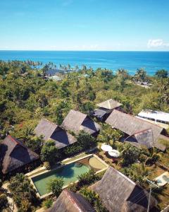 an aerial view of a resort with the ocean in the background at Three Little Birds Resort in Anda