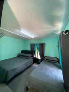1 Schlafzimmer mit 2 Betten und einem Fenster in der Unterkunft Mini Homestay Arifz Zai in Batu Kurau