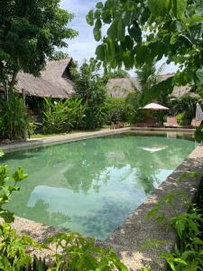 a swimming pool in front of a villa at Three Little Birds Resort in Anda