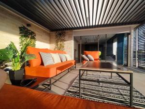 un salon avec des chaises orange et une table dans l'établissement Splendide Villa Safari avec piscine, à Tamraght Ouzdar