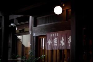 a building with a sign on the front of it at Busuitei in Hida