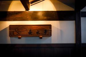 a wooden picture on a wall in a room at Busuitei in Hida