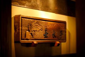 une plaque en bois sur un mur avec inscription sur celui-ci dans l'établissement Busuitei, à Hida