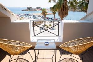 een balkon met een tafel en stoelen en uitzicht op het strand bij Key Largo in Bandol