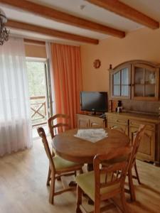 a dining room with a table and chairs and a television at Hotel Yavir in Yaremche