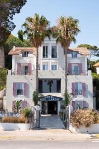 a white building with palm trees in front of it at Key Largo in Bandol