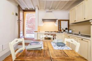 a kitchen with a wooden table with wine glasses at Vicolo Curtatone 30 in Foiano della Chiana