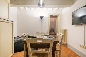 a dining room with a table and chairs and a bed at Vicolo Curtatone 30 in Foiano della Chiana