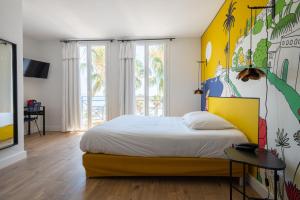 - une chambre avec un grand lit et une tête de lit jaune dans l'établissement Key Largo, à Bandol