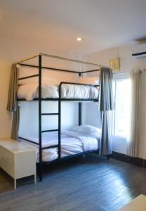 1 Schlafzimmer mit 2 Etagenbetten und einem Fenster in der Unterkunft HideSeek Hostel Vientiane Thai embassy in Vientiane