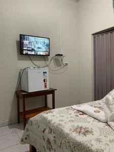 um quarto com uma cama e uma televisão na parede em Pousada Vidal em Carolina