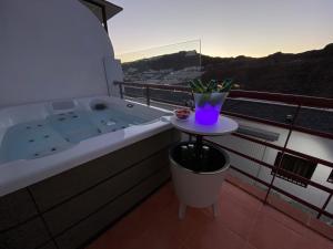 uma banheira sentada em cima de uma varanda em Villa Mogan Mall, con jacuzzi y PlayStation 5 em Puerto Rico de Gran Canaria