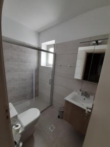 a bathroom with a toilet and a sink and a shower at Matala Prime Villas in Matala
