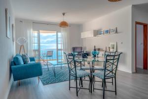 uma sala de jantar e sala de estar com mesa e cadeiras em Casa Serena Apartments em Arco da Calheta