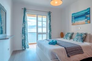 a bedroom with a bed and a large window at Casa Serena Apartments in Arco da Calheta