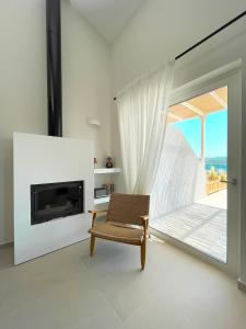 ein Wohnzimmer mit einem Stuhl und einem Kamin in der Unterkunft Triantafilia Guesthouse in Agio Apóstoloi