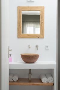 bagno con lavandino e specchio di Triantafilia Guesthouse a Áyioi Apóstoloi