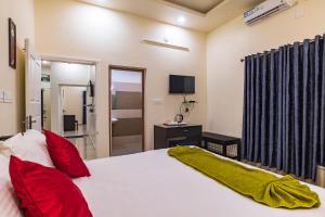 - une chambre avec un grand lit blanc et des oreillers rouges dans l'établissement Pine Clough Holidays Vagamon, à Vagamon