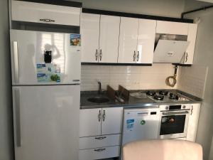 a kitchen with white cabinets and a white refrigerator at Karakoçan Apart otel in Karakoçan