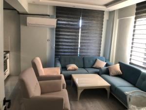 a living room with a blue couch and two chairs at Karakoçan Apart otel in Karakoçan