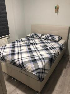 een bed met een geruite deken erop bij Karakoçan Apart otel in Karakoçan