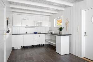 a white kitchen with white cabinets and a counter at RoaldsPiren Stavanger in Stavanger