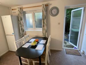 een eetkamer met een tafel en een klok aan de muur bij 3-bedroom home with free parking in Canterbury