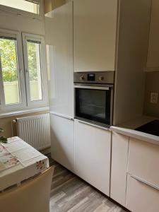 cocina con armarios blancos y microondas en Lovely flat in the city center, en Bratislava