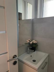 un baño con lavabo con un jarrón de flores. en Lovely flat in the city center, en Bratislava