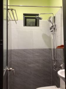 a bathroom with a shower with a toilet and a window at Abalone House Quy Nhơn in Quy Nhon +16 photos