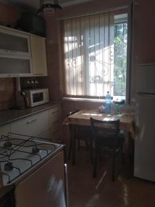 a kitchen with a stove and a table with chairs at Однокомнатная квартира у моря in Gagra