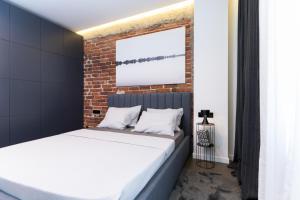The Grey Apartment في صوفيا: سرير في غرفة بجدار من الطوب