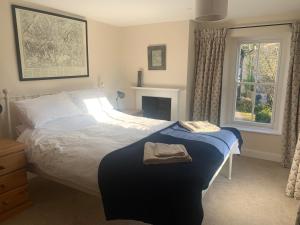 a bedroom with a large bed and a window at Cwmbach Cottage, Hay on Wye in Glasbury