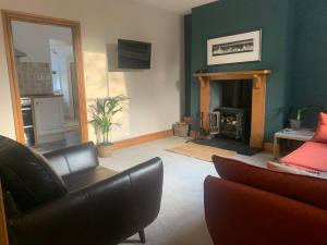 a living room with a couch and a fireplace at Cwmbach Cottage nr Hay on Wye in Glasbury