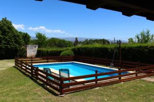 a pool with a wooden fence around it at Vista del sol in Villa Ciudad Parque