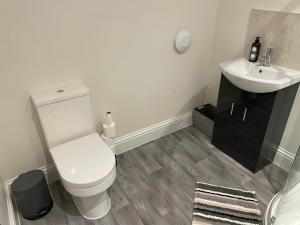 a bathroom with a white toilet and a sink at The Up And Over in Northallerton