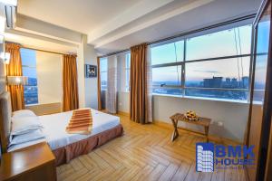 a hotel room with a bed and a large window at BMK House Apartments in Kampala +90 photos