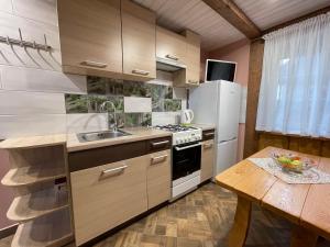a kitchen with a sink and a refrigerator and a table at Poilsis Preiloje-91 in Neringa